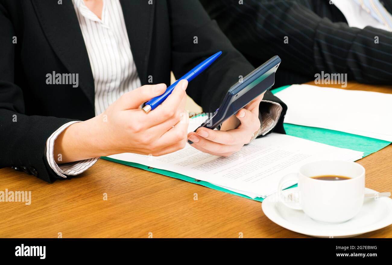 Businesswoman checking the numbers using a calculator Stock Photo - Alamy