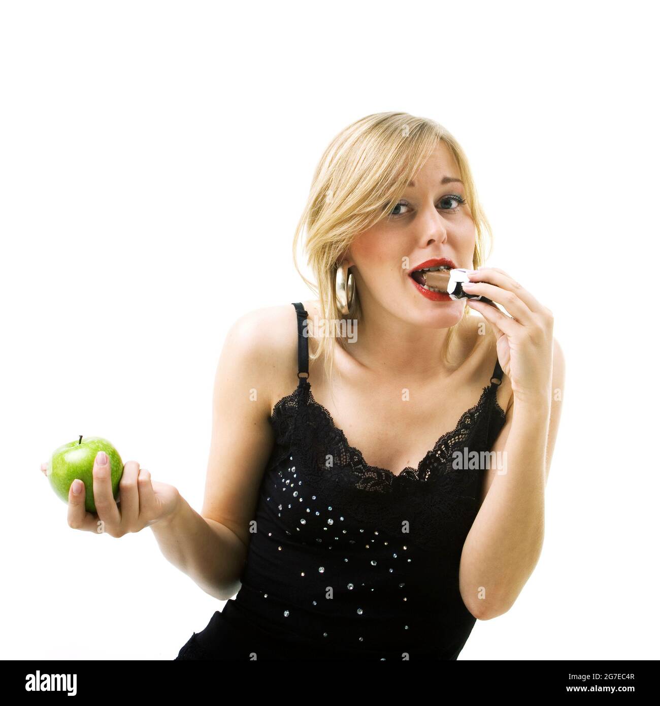 Food and healthy nutrition - Woman eating candy instead of apple Stock Photo