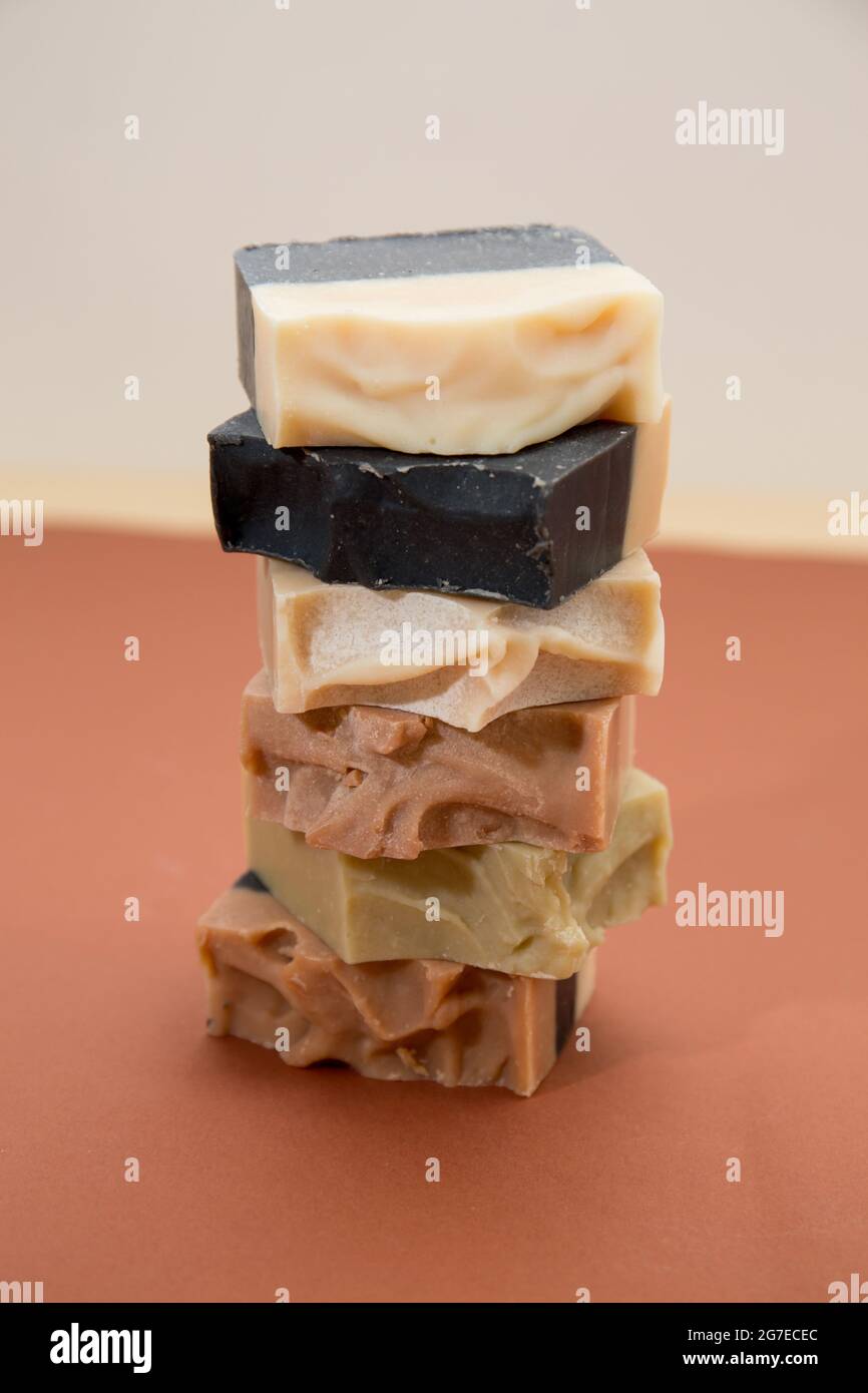 Vertical shot of stacked handmade bars of hand soap on a brown surface