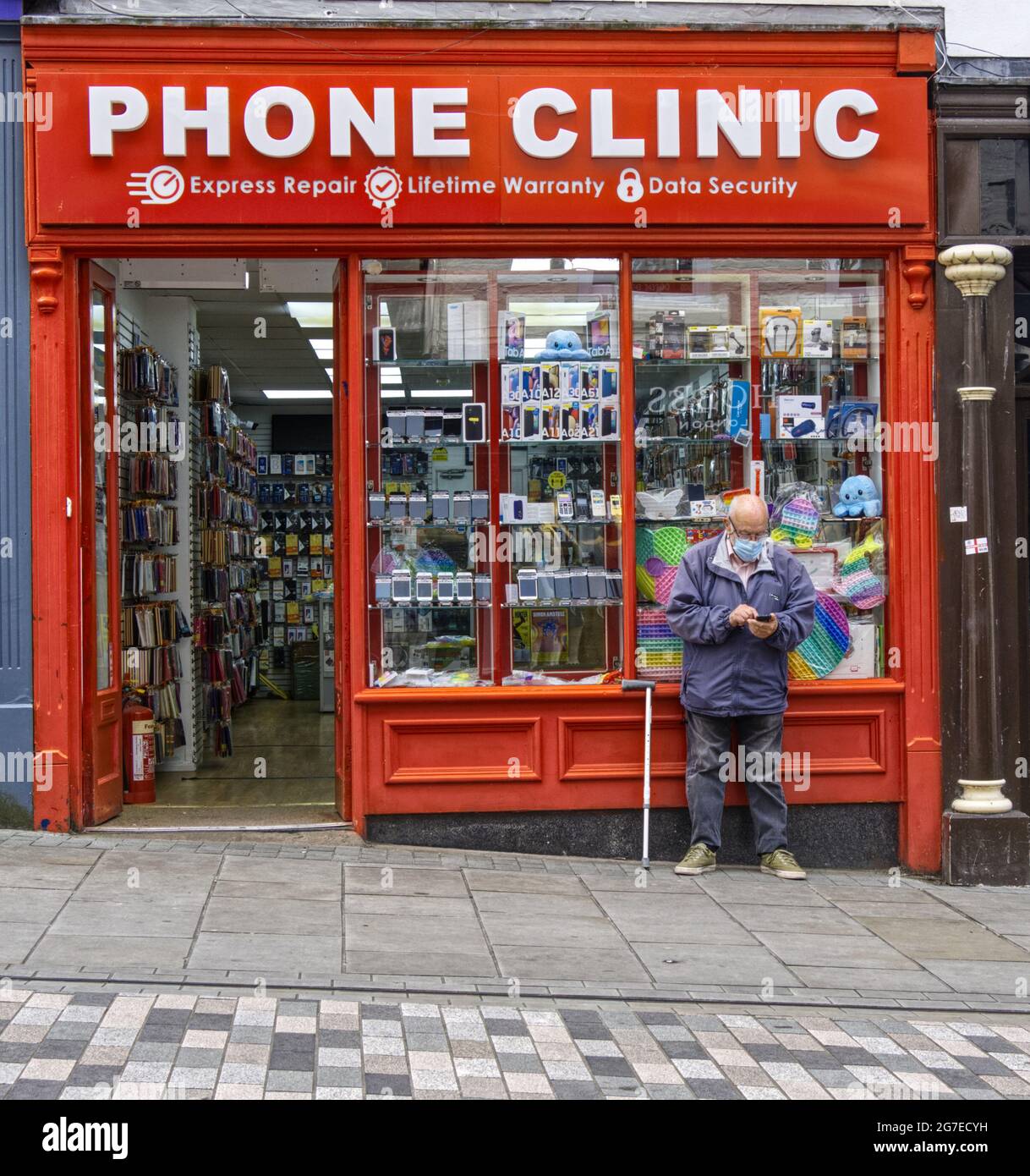 Phone Clinic shop with potential customer trying to get phone to work, Shrewsbury, Shropshire, UK Stock Photo