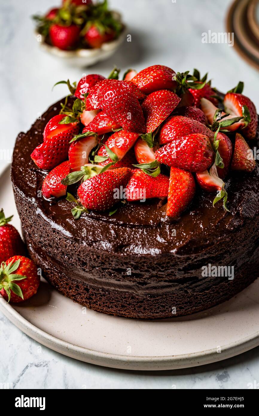 A chocolate cake decorated with fresh chopped strawberries Stock Photo ...