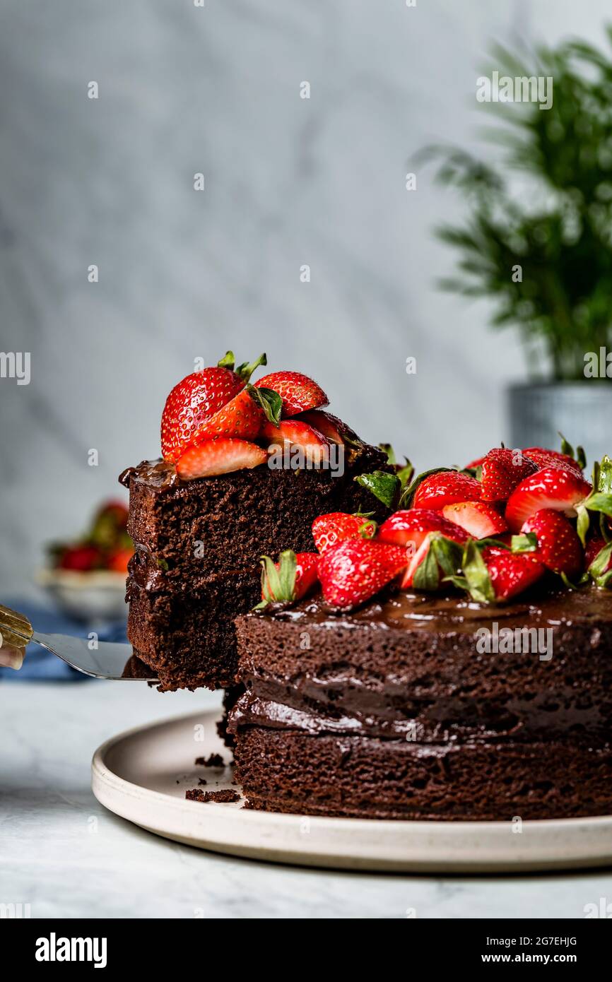 A chocolate cake decorated with fresh chopped strawberries Stock Photo ...