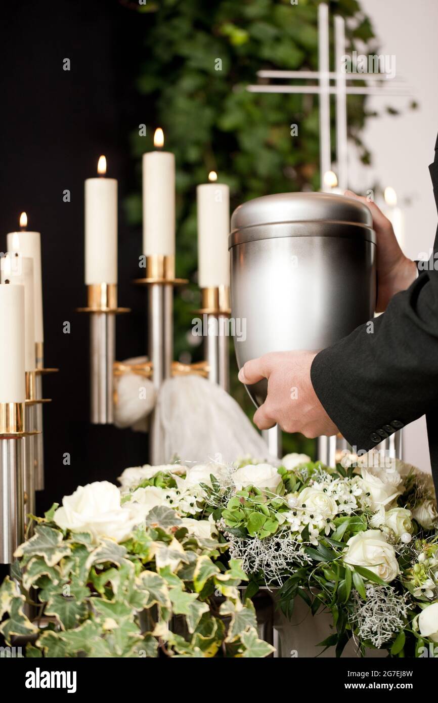Religion, death and dolor  - mortician on funeral with urn Stock Photo