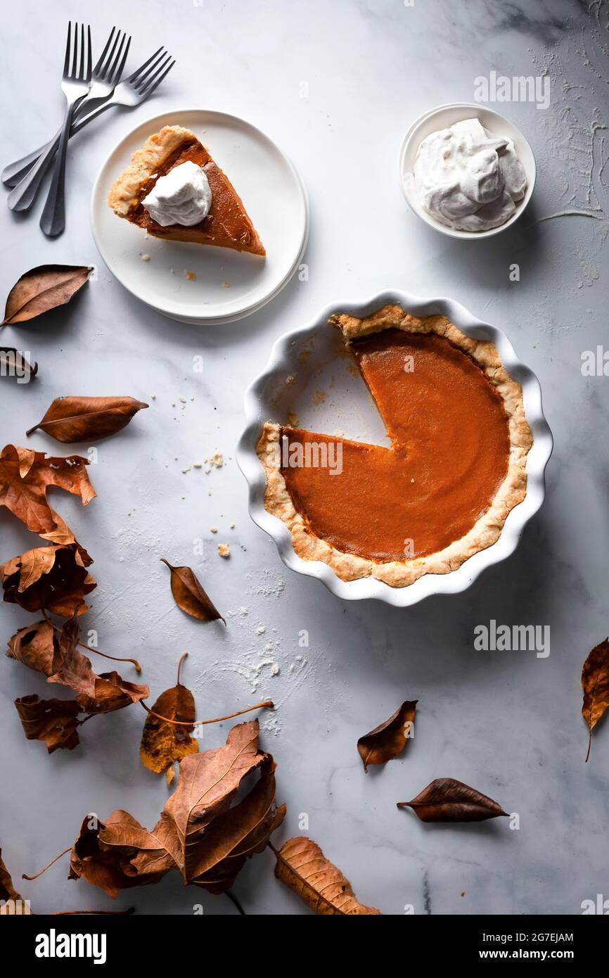 Pumpkin pie on a marble surface with whipped cream Stock Photo