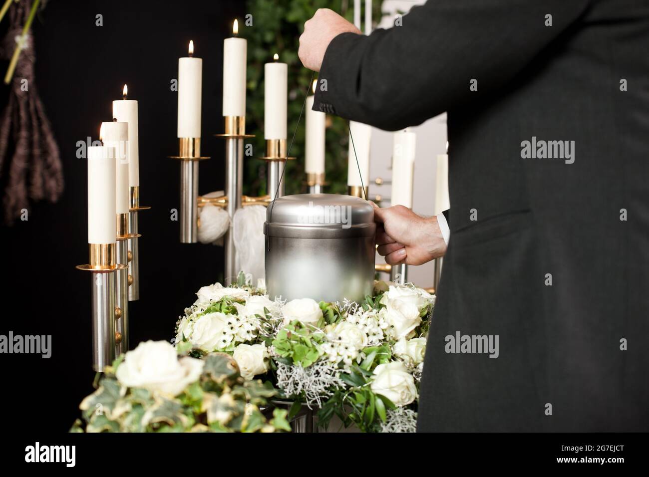 Religion, death and dolor  - mortician on funeral with urn Stock Photo