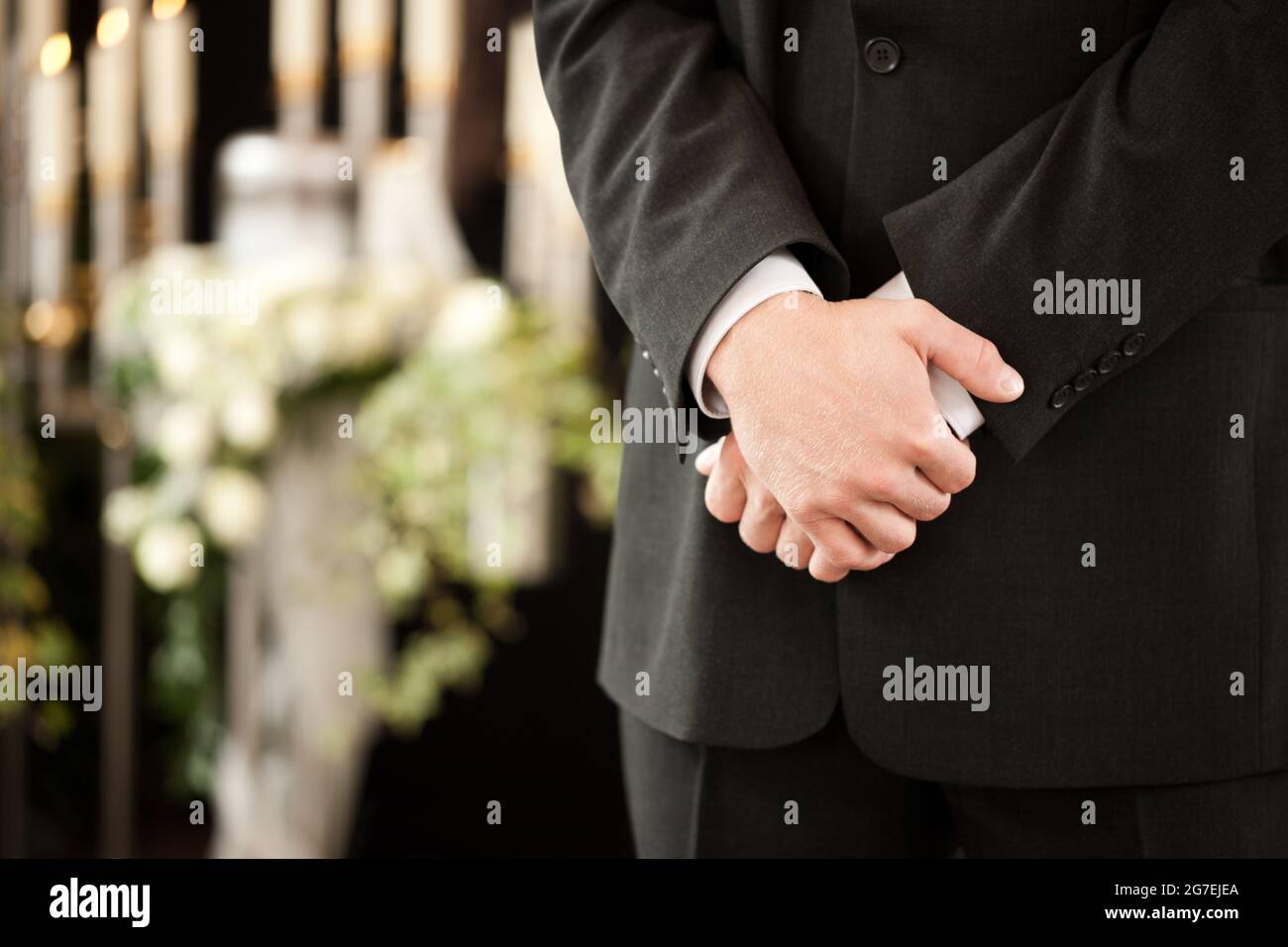 Religion, death and dolor  - undertaker at funeral standing in front or urn Stock Photo