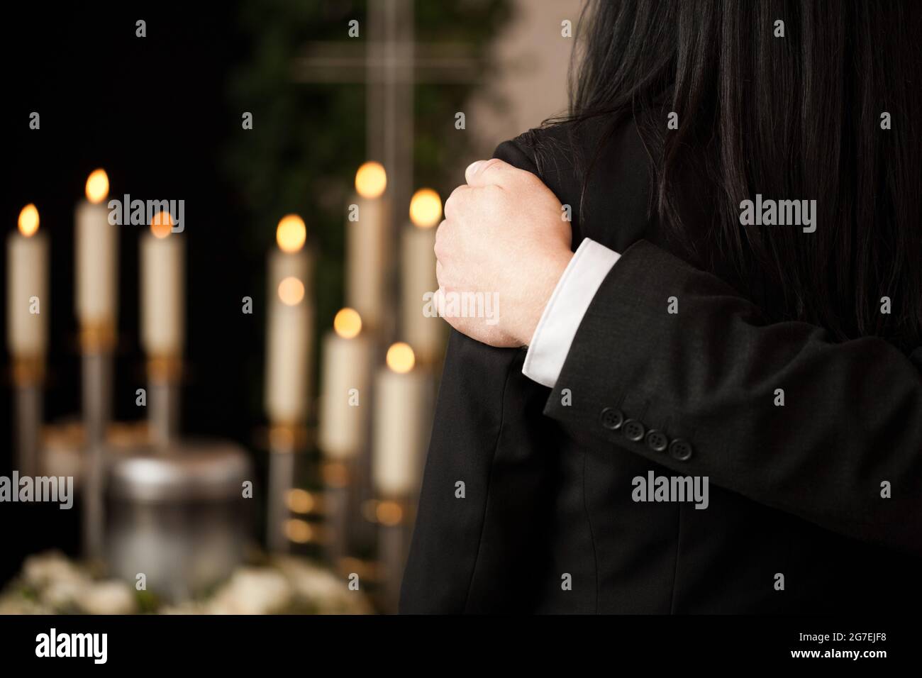 Religion, death and dolor  - couple at funeral consoling each other in view of the loss Stock Photo