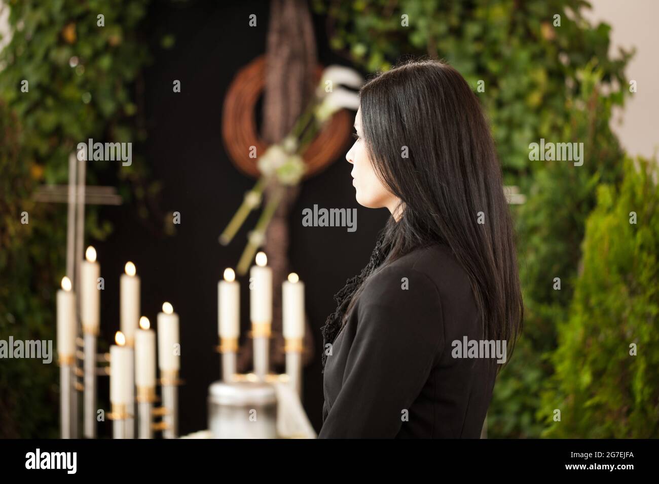 Religion, death and dolor  - woman at urn funeral mourning the death of a loved person Stock Photo