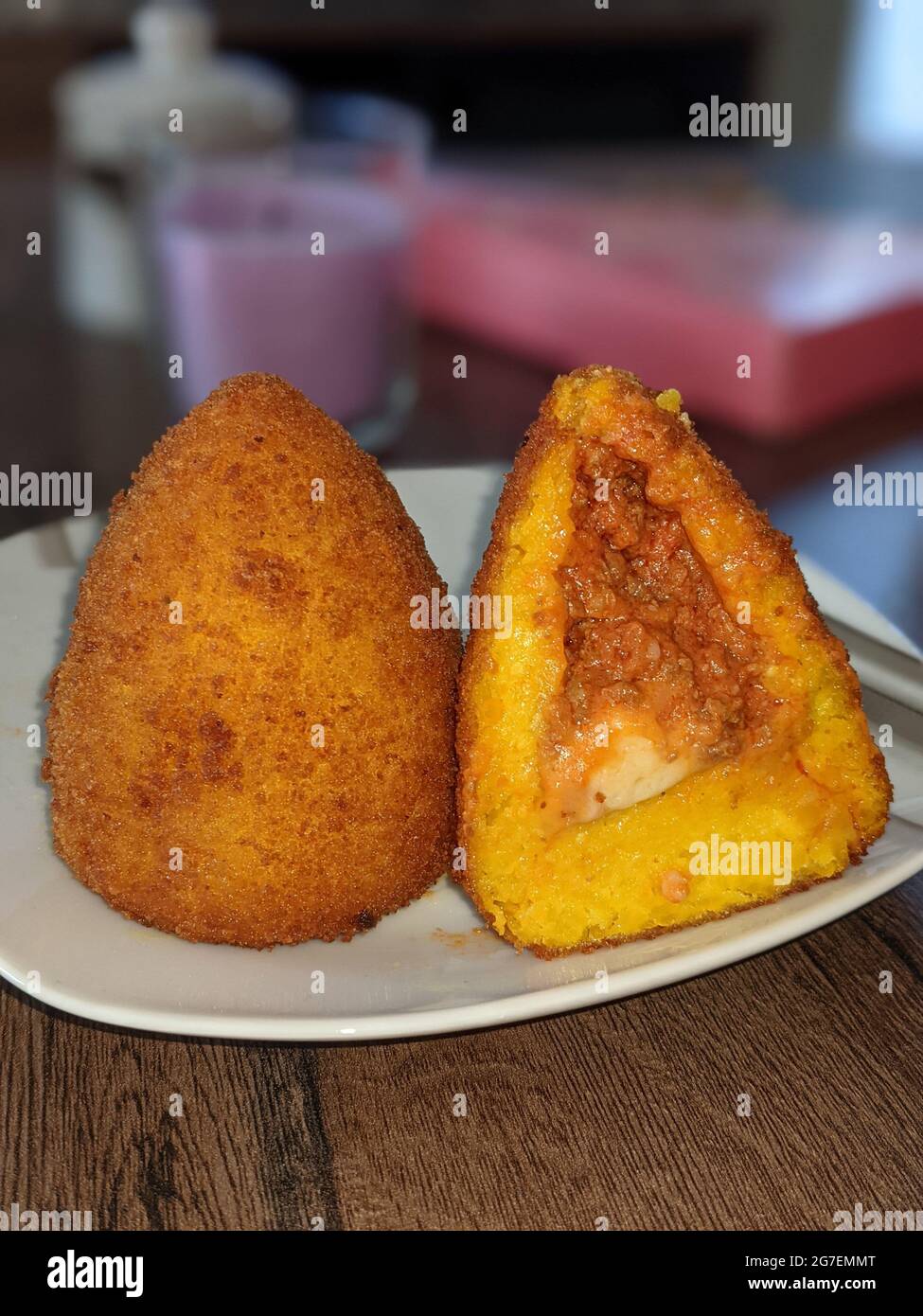 Traditional street food from Sicilia, Taormina, Arancini Siciliani. Deep fried risotto rice balls stuffed with meat ragu. Stock Photo