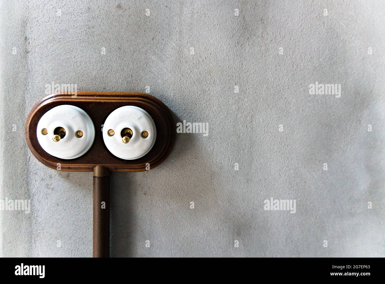 Two vintage light switches on a concrete wall Stock Photo