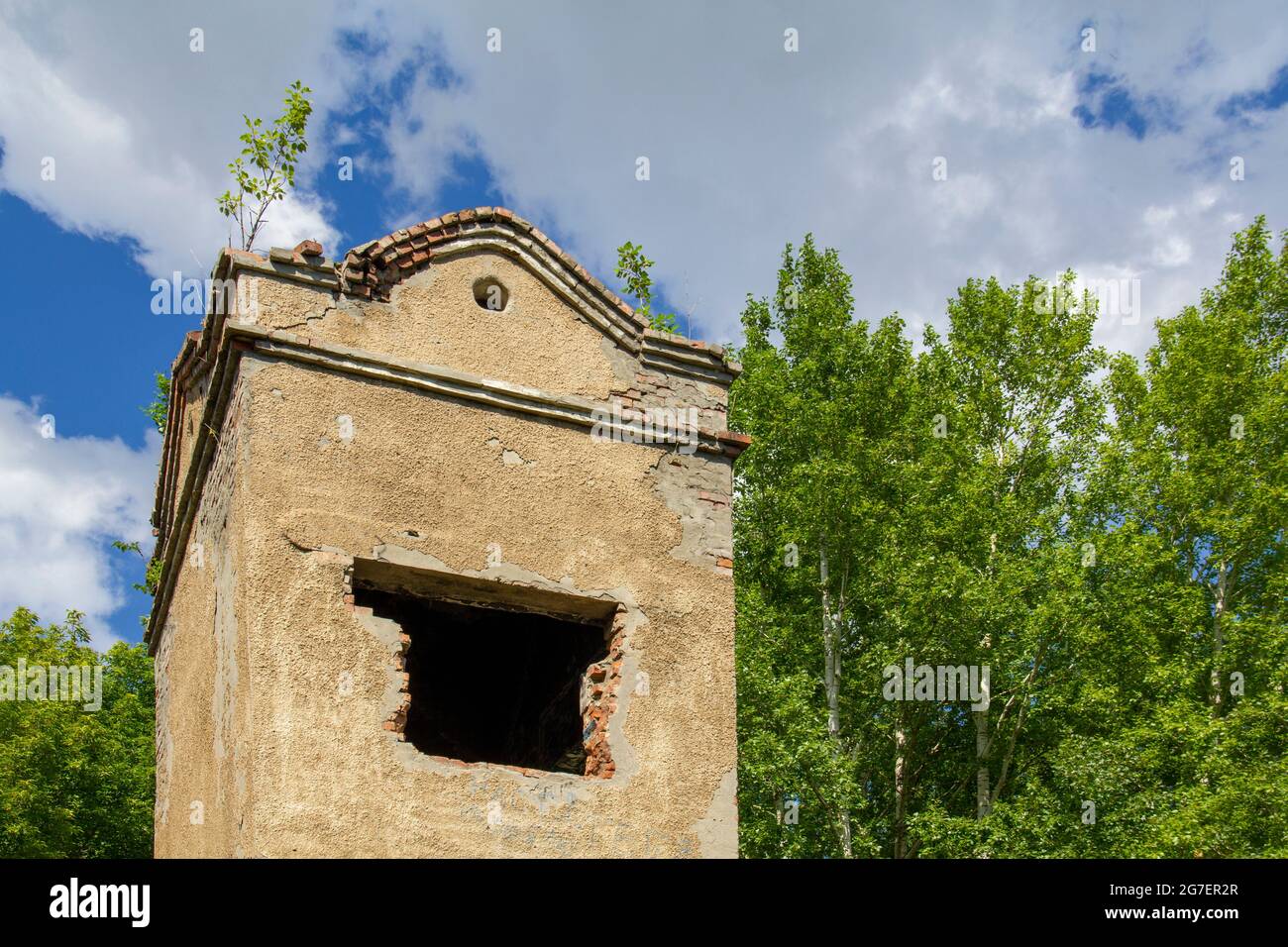 Ancient dilapidated tower in a modern city park. Stock Photo
