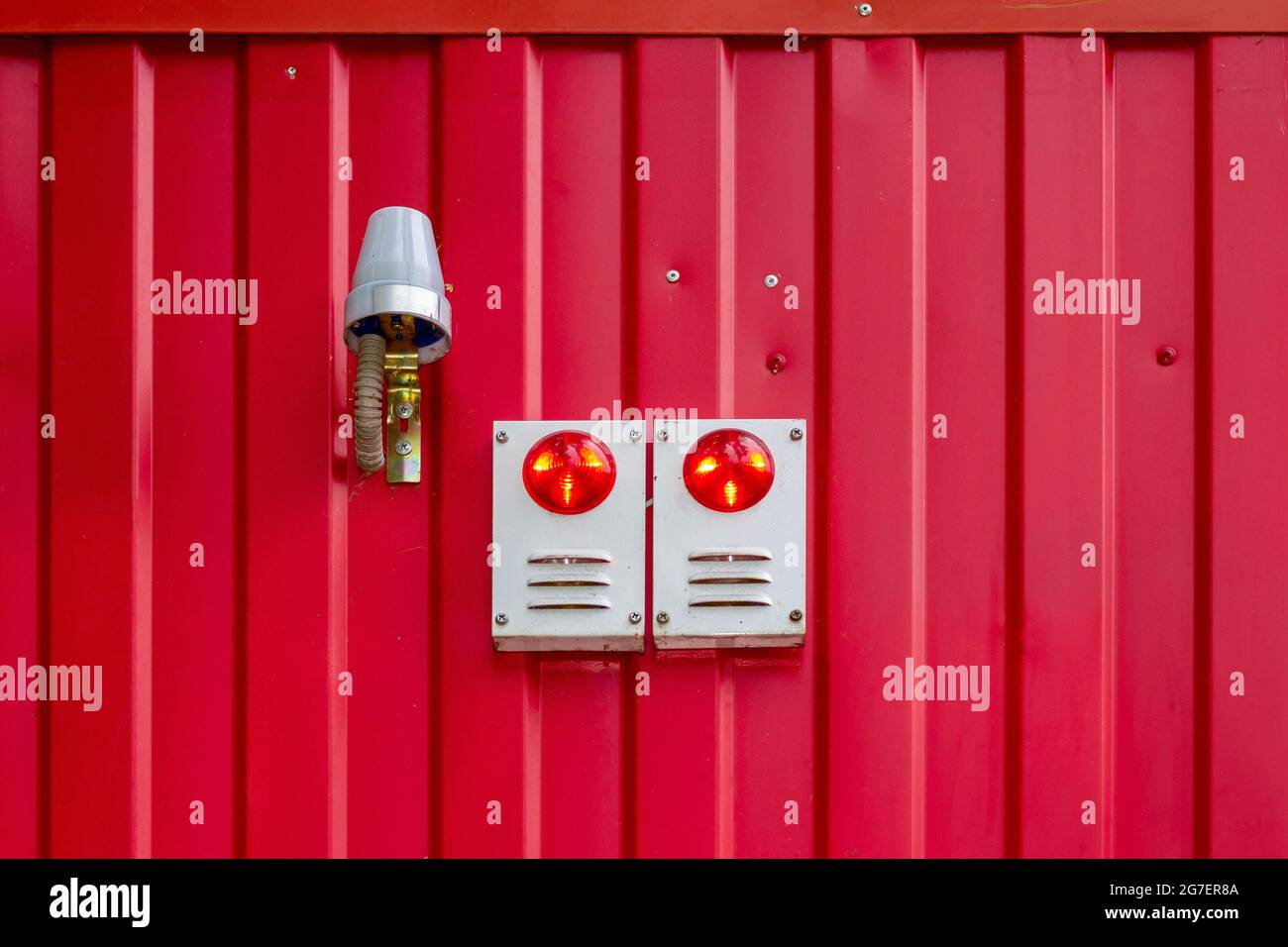 Sound and light alarm system block on the red wall of the building. Stock Photo