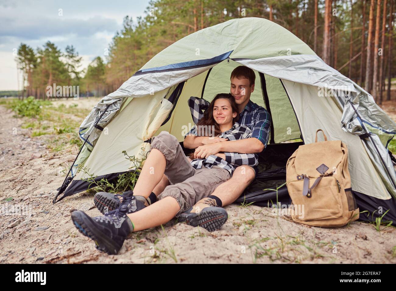 Romantic couple camping outdoors and sitting in a tent. Happy Man and ...