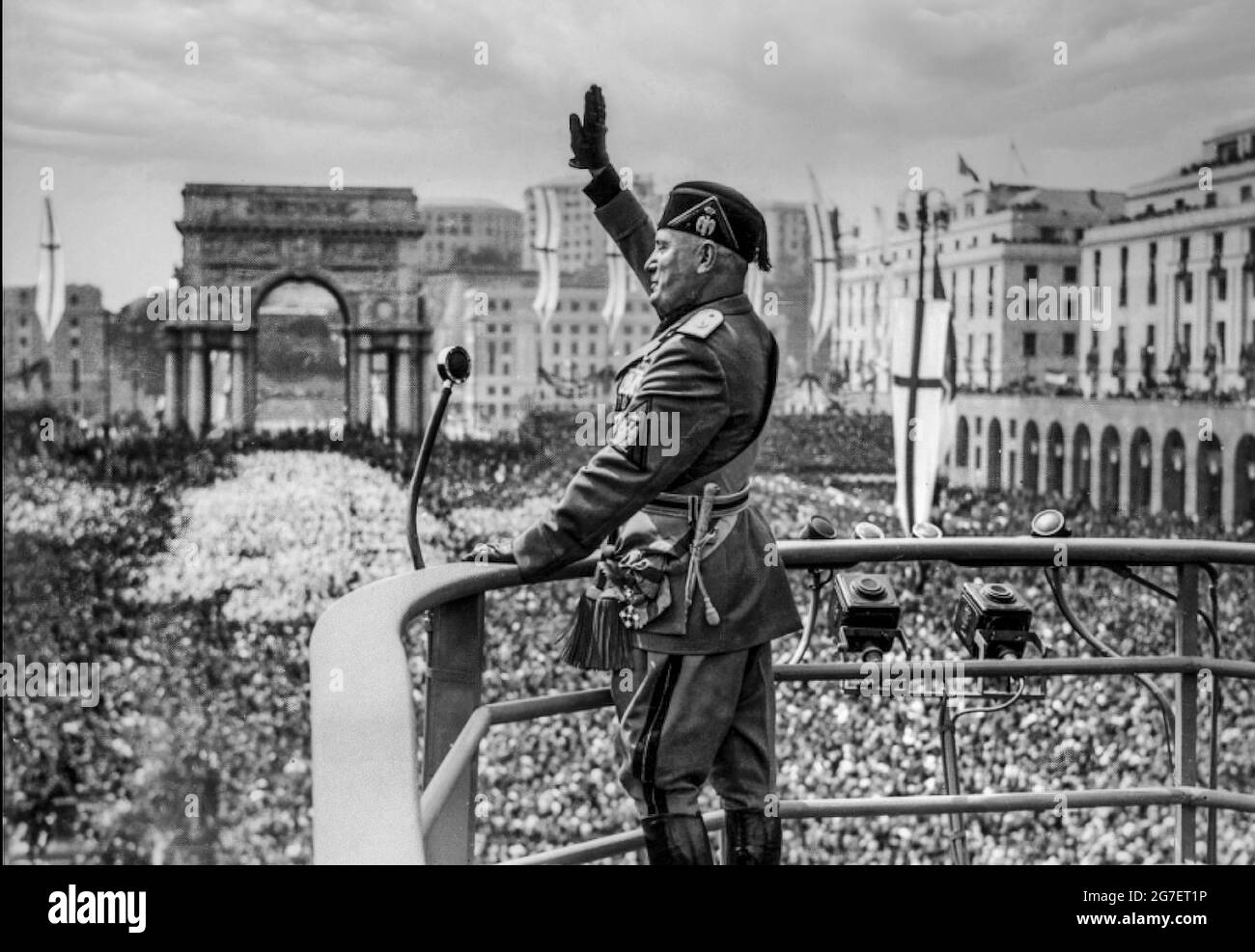 MUSSOLINI SPEECH 1930s IL DULCE ROME ITALY SPEECH FACIST SALUTE Italian fascist dictator Benito Mussolini at the height of his popularity, in military uniform with microphone making a speech on raised podium, facist saluting salute to ecstatic Italian crowds in Rome Italy in the 1930s. Stock Photo