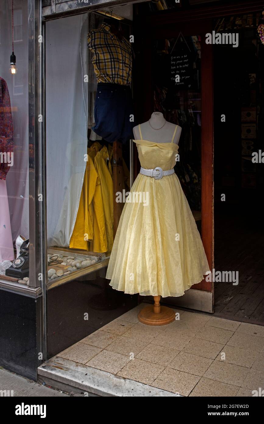 Yellow vintage dress in to doorway of Armstrongs vintage clothing store in Clerk Street, Newington, Edinburgh, Scotland, UK. Stock Photo