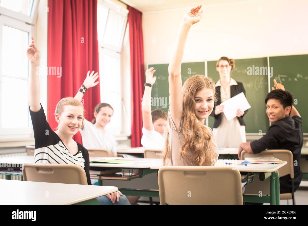 Math teacher standing in front of students who are well prepared to answer Stock Photo