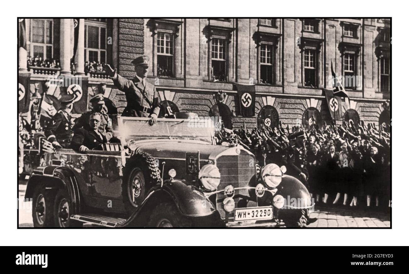 ANSCHLUSS 1938 Austria, Vienna: Adolf Hitler standing in an open top Mercedes car, greets the cheering crowd in Vienna, next to him is the Austrian Chancellor Arthur Seyss-Inquart. On March 12, 1938, soldiers of the German Wehrmnacht crossed the border to the Alpine republic. The 'Anschluss' (occupation) is carried out amid the cheers of hundreds of thousands of Austrians; Austria ceased to exist for seven years. Stock Photo
