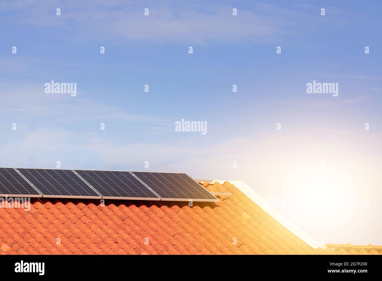 Solar photovoltaic panels on a roof at sunset. Clean energy modern house or company concept image. Stock Photo