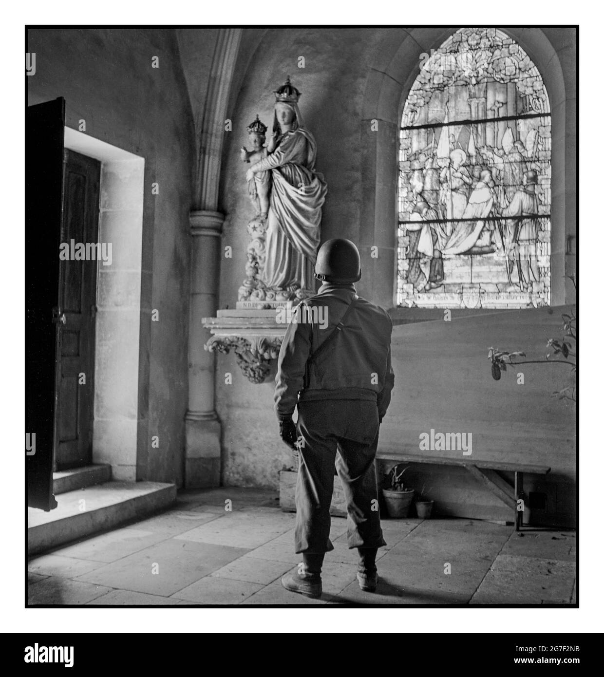 WW2 GI American Soldier pauses to look at a statue of the Madonna and Child in a church, in Italy Europe during World War II  Toni Frissell photographer taken between 1940 and 1945 -  World War, 1939-1945--Religious aspects Churches--Europe--1940-1950, Soldiers--Europe--1940-1950 Stock Photo