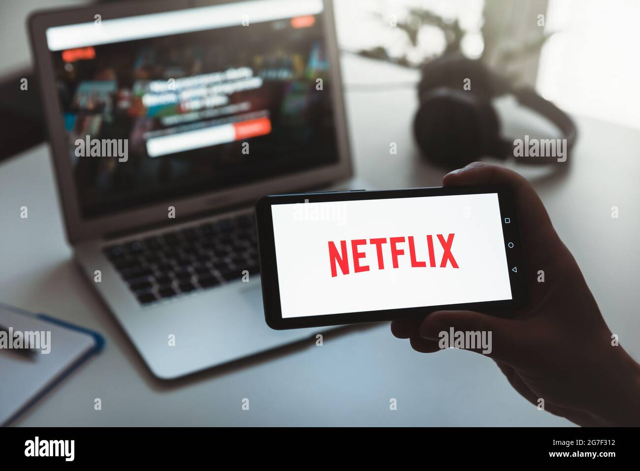 Wroclaw, Poland - JUN 17, 2021: Man with Netflix logo on screen. Netflix is most popular video streaming platform. Stock Photo