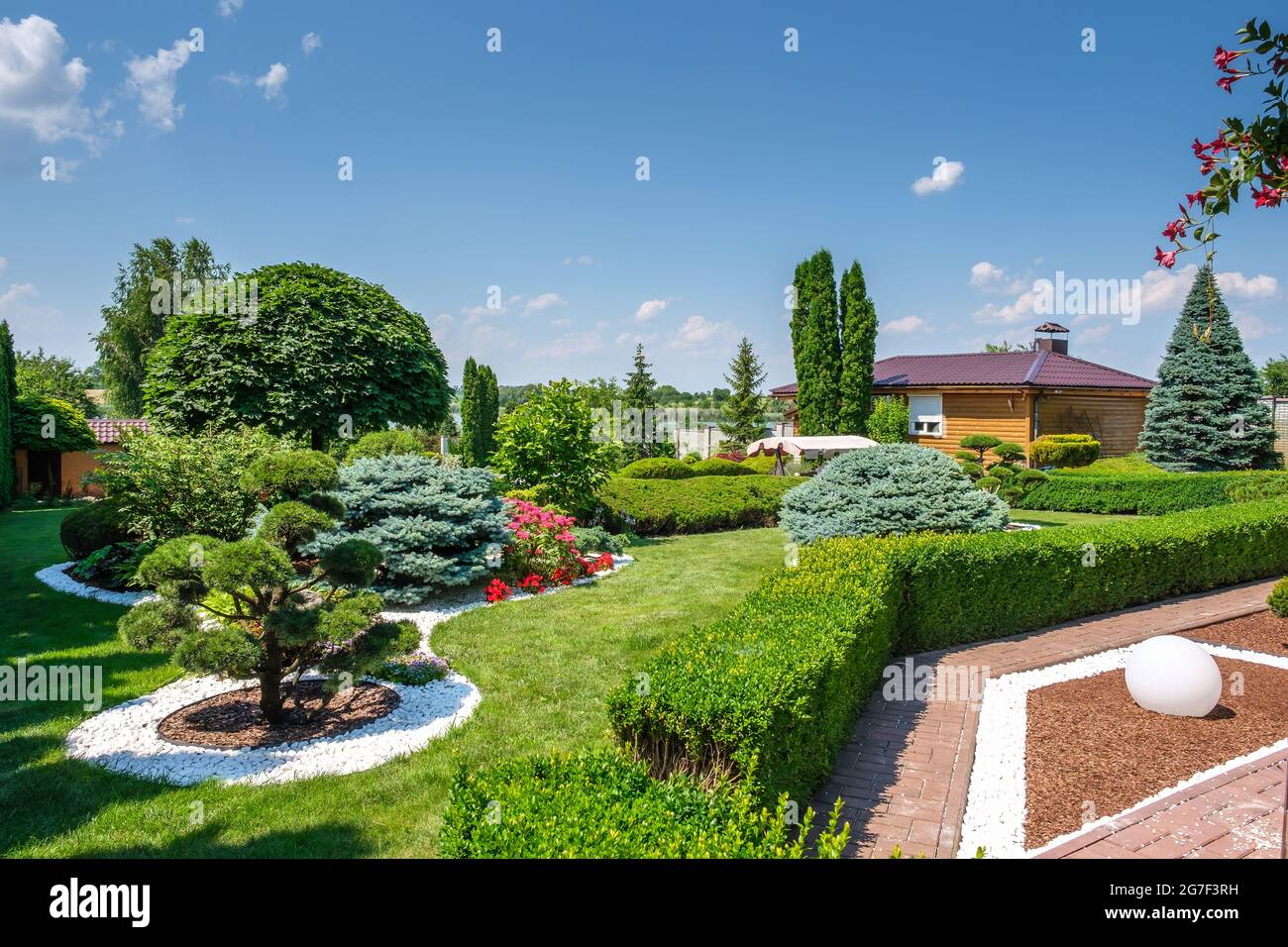 Beautiful backyard garden with nicely trimmed trees, bushes and stones  Stock Photo - Alamy