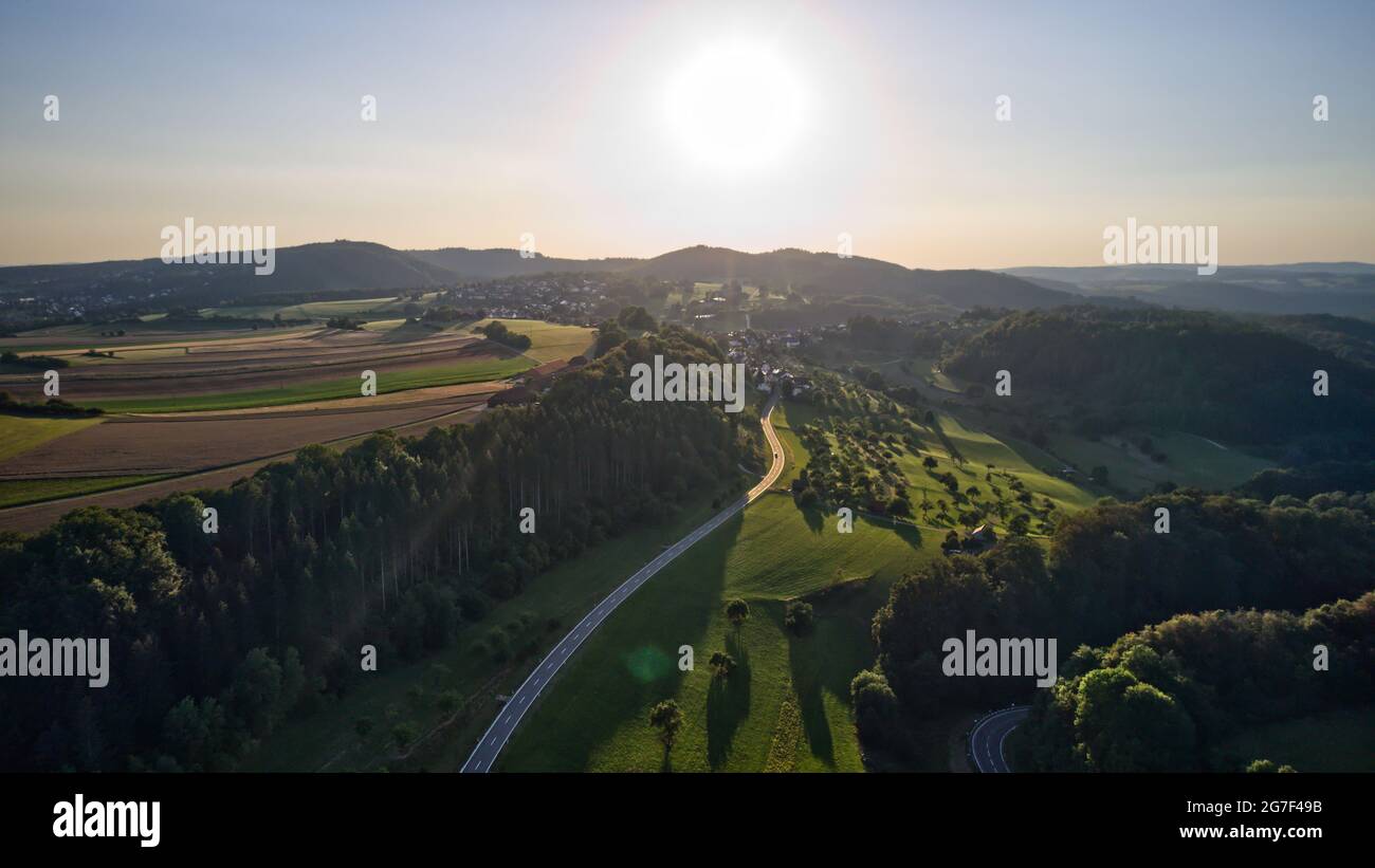 Aerial view of green dense forests and a road on a sunny day Stock ...