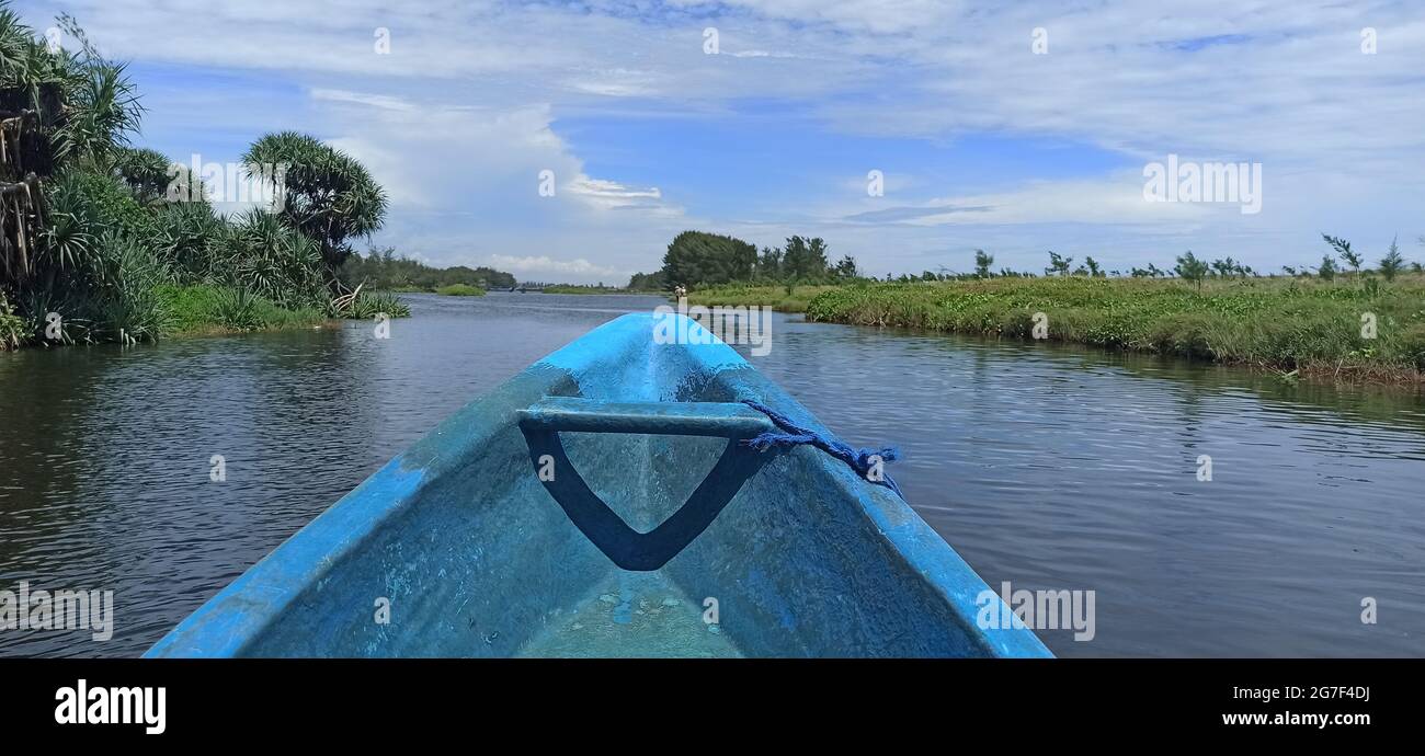 Closeup of an old blue boat on a river surrounded by greenery in the ...