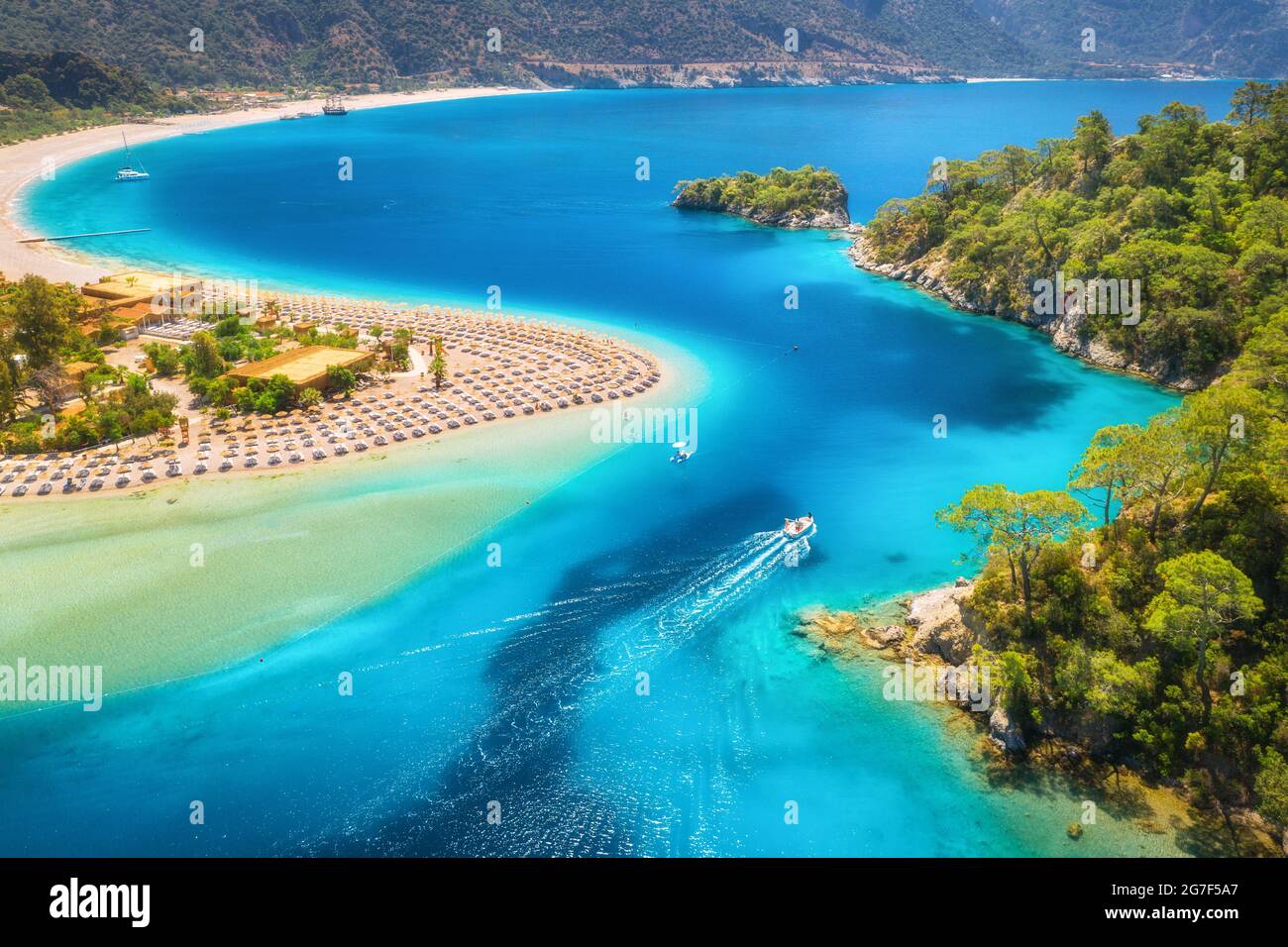 Aerial view of sandy beach, blue sea and speed boat at sunrise Stock Photo
