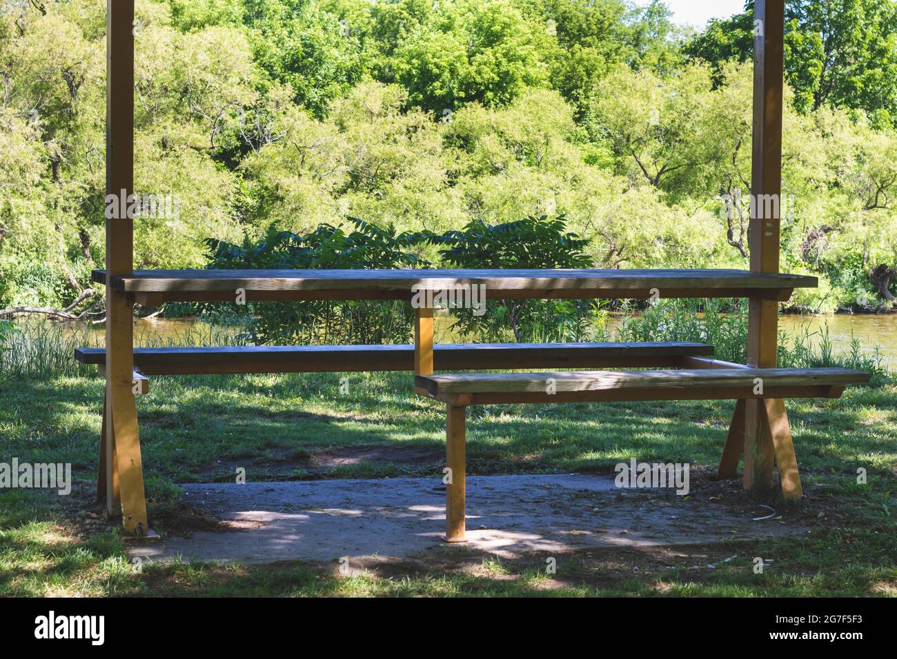 Wheelchair accessible wooden picnic table. Trees in the background. Stock Photo