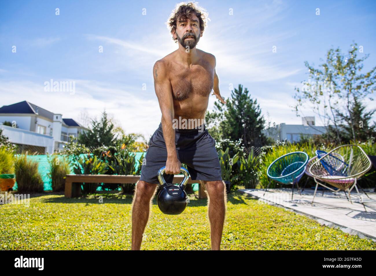 Middle age man training crossfit and weightlifting in his backyard Stock Photo