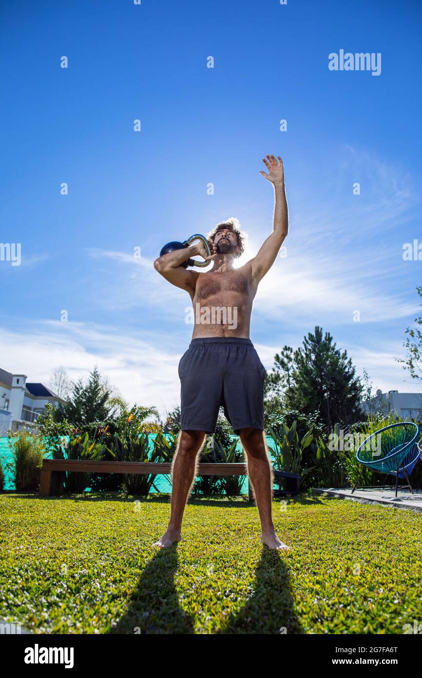Middle age man training crossfit and weightlifting in his backyard Stock Photo
