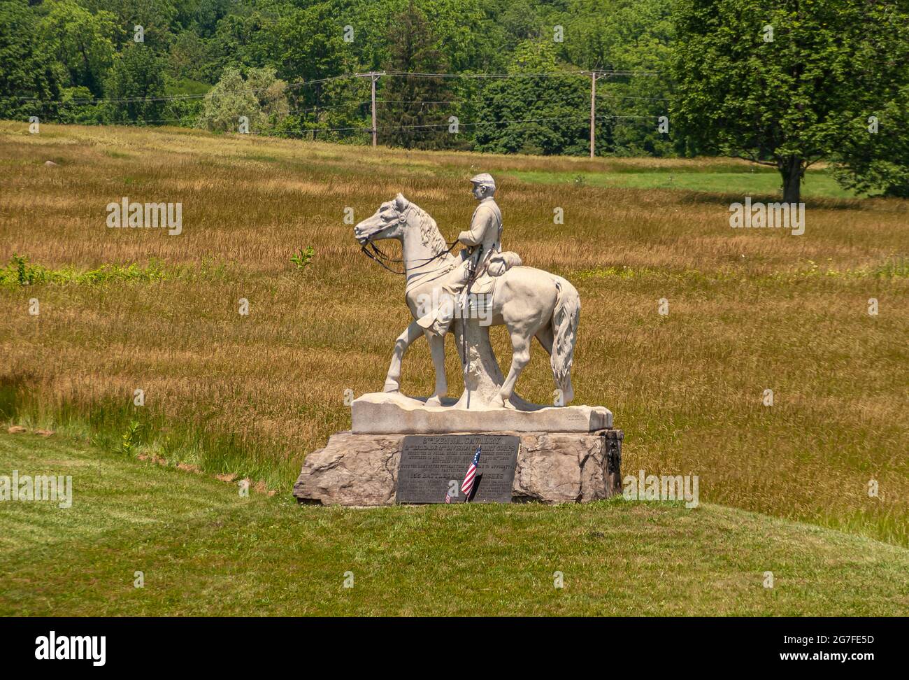 Gettysburg, PA, USA - June 14, 2008: Battlefield monuments.8th Pennsylvania Cavalry white equestrian statue in green-brown weed field with green fores Stock Photo