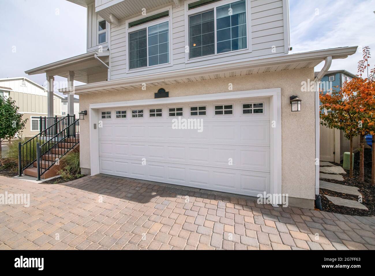 Garage attached on a two storey house with bricks pavement Stock Photo