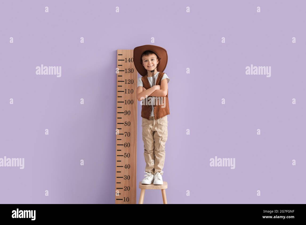 Little boy measuring height near color wall Stock Photo