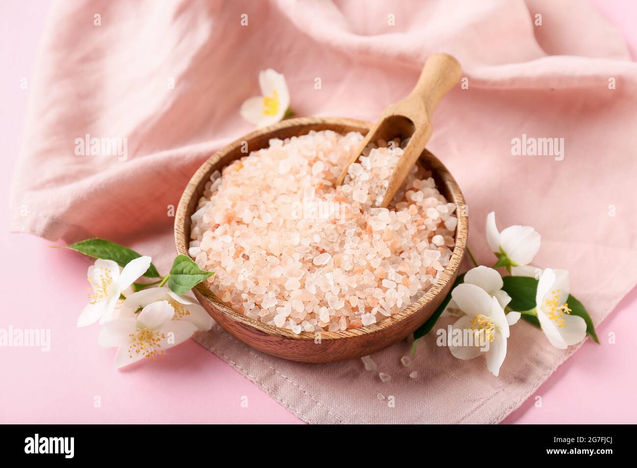Composition with bowl of sea salt and jasmine flowers on color background Stock Photo