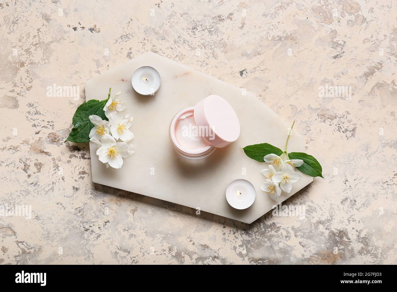 Composition with jar of cream, burning candles and jasmine flowers on grunge background Stock Photo