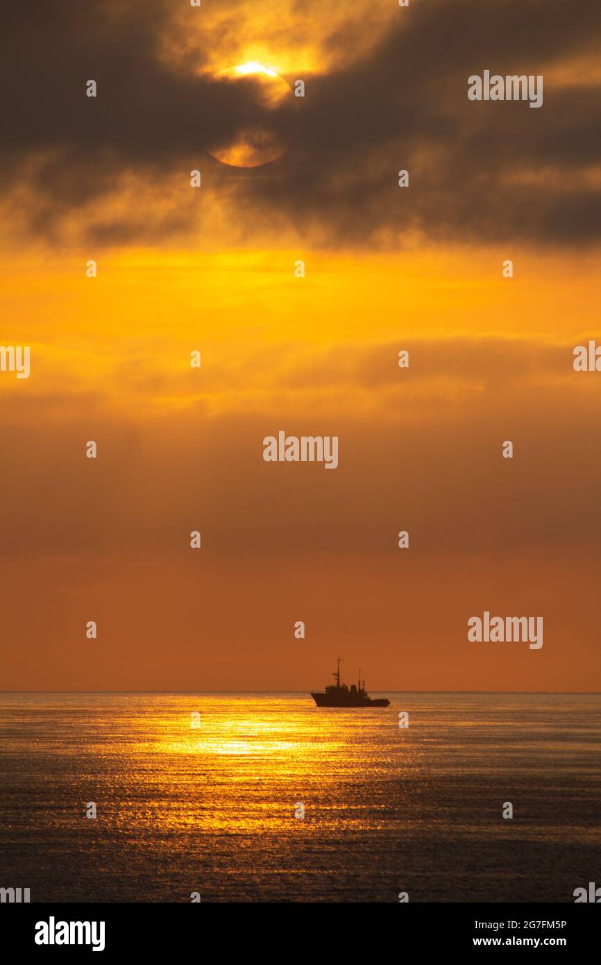 Vertical shot of a ship in the sea during sunset Stock Photo - Alamy