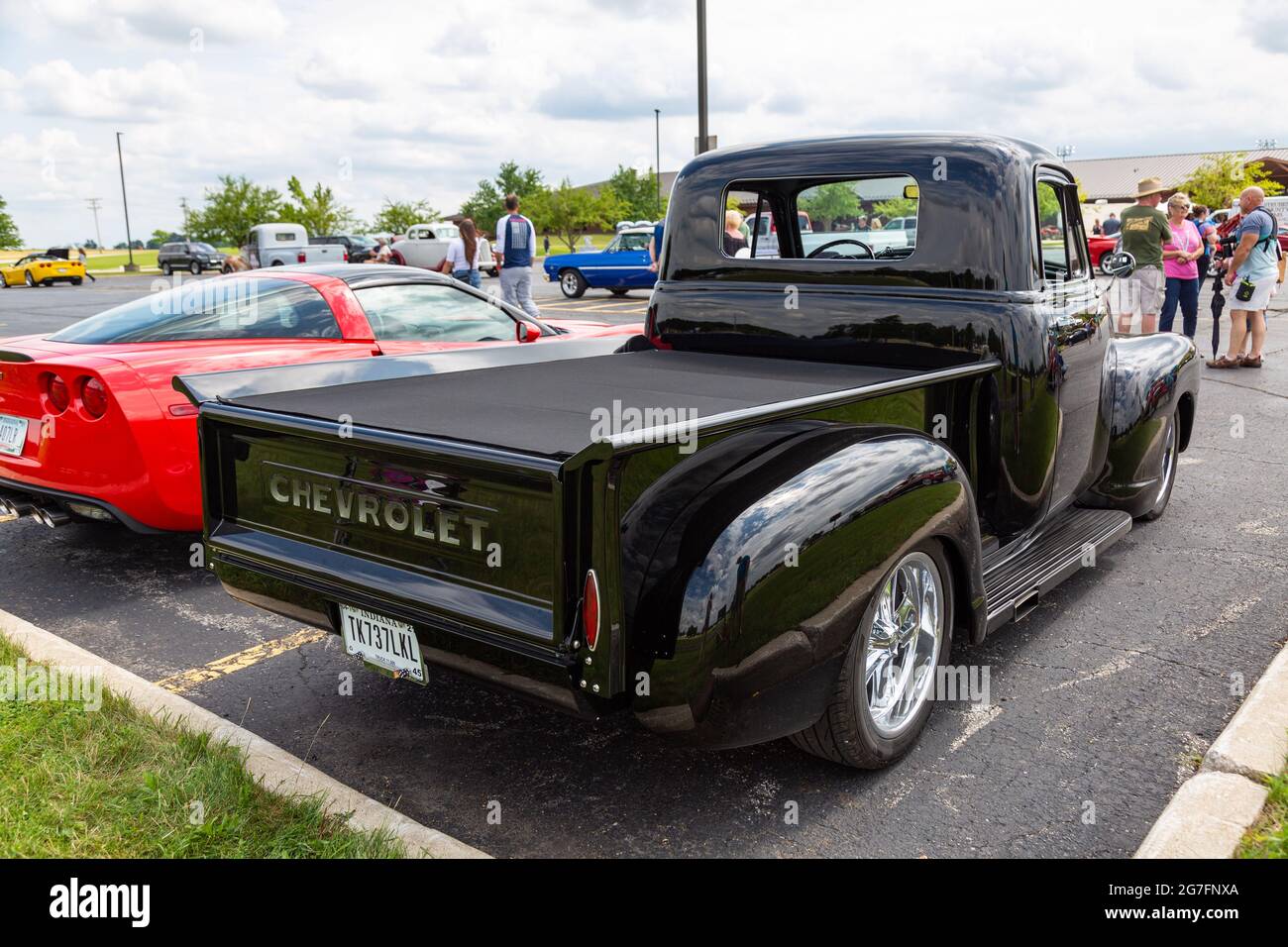 The bed of a classic black Chevrolet pickup truck on display at a car