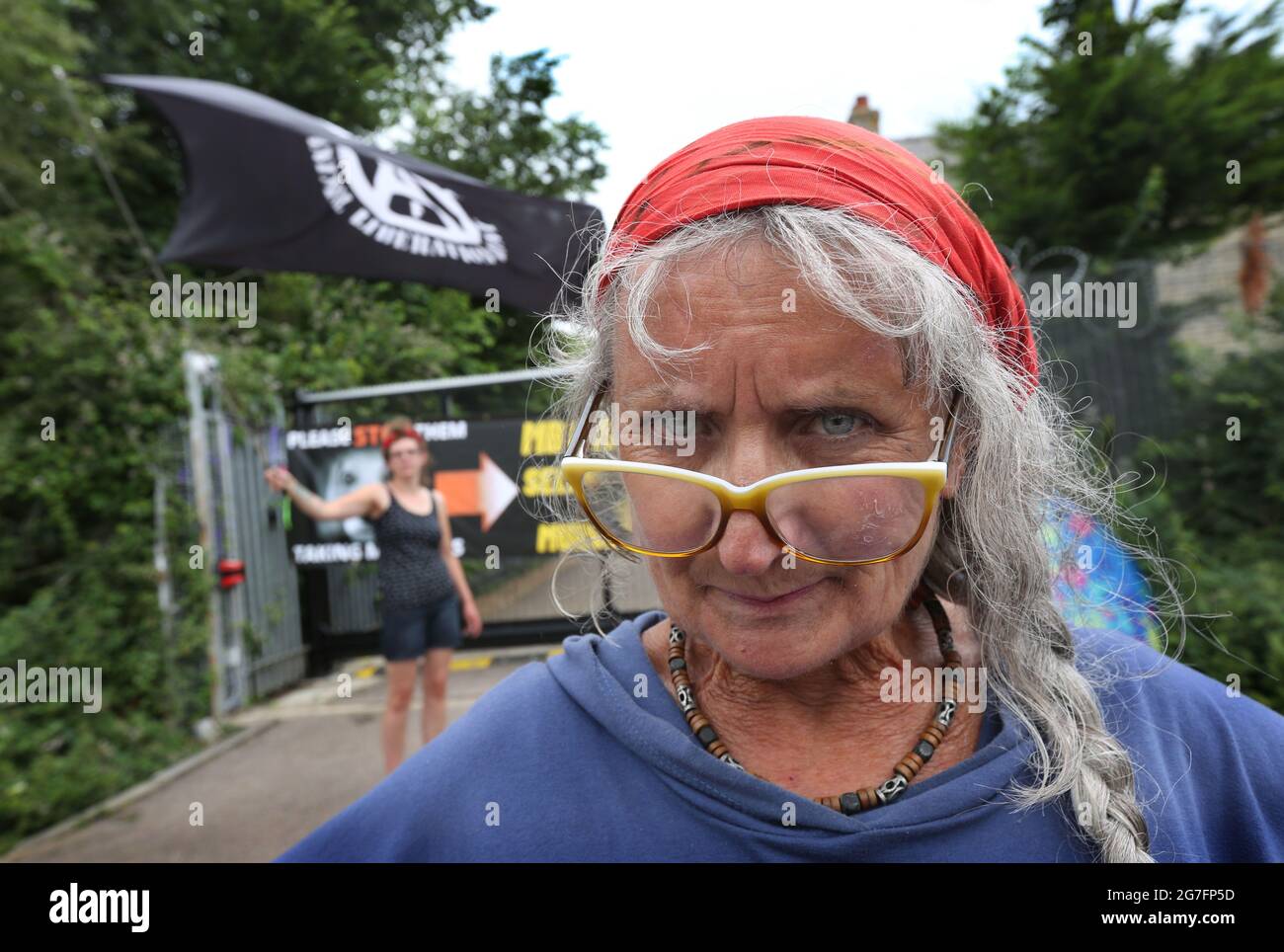 Huntingdon, UK. 13th July, 2021. An Animal Liberation Front (ALF) flag is  being waved behind camp founder Polly during the  rights  activists occupy Camp Beagle, a protest camp on the roadside