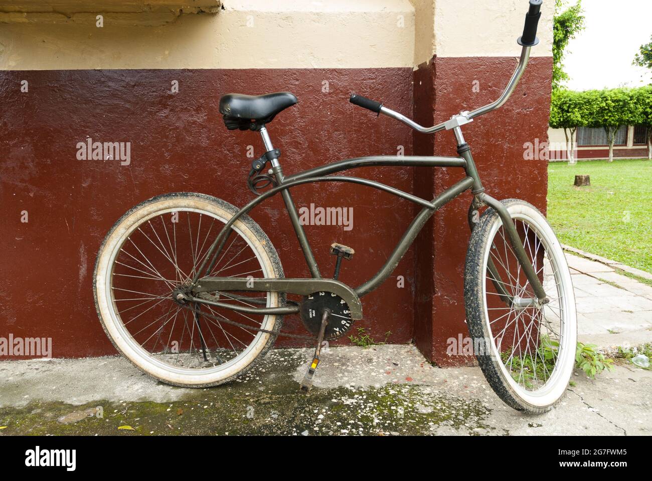 Old bicycle leaning on exterior wall. Stock Photo