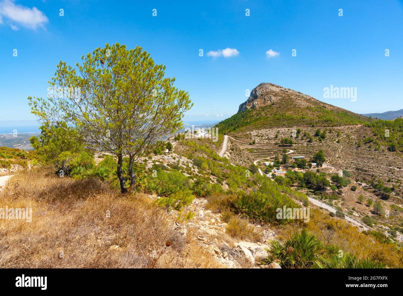 Road winding through mountains toward to rock outcrop at summit past ...
