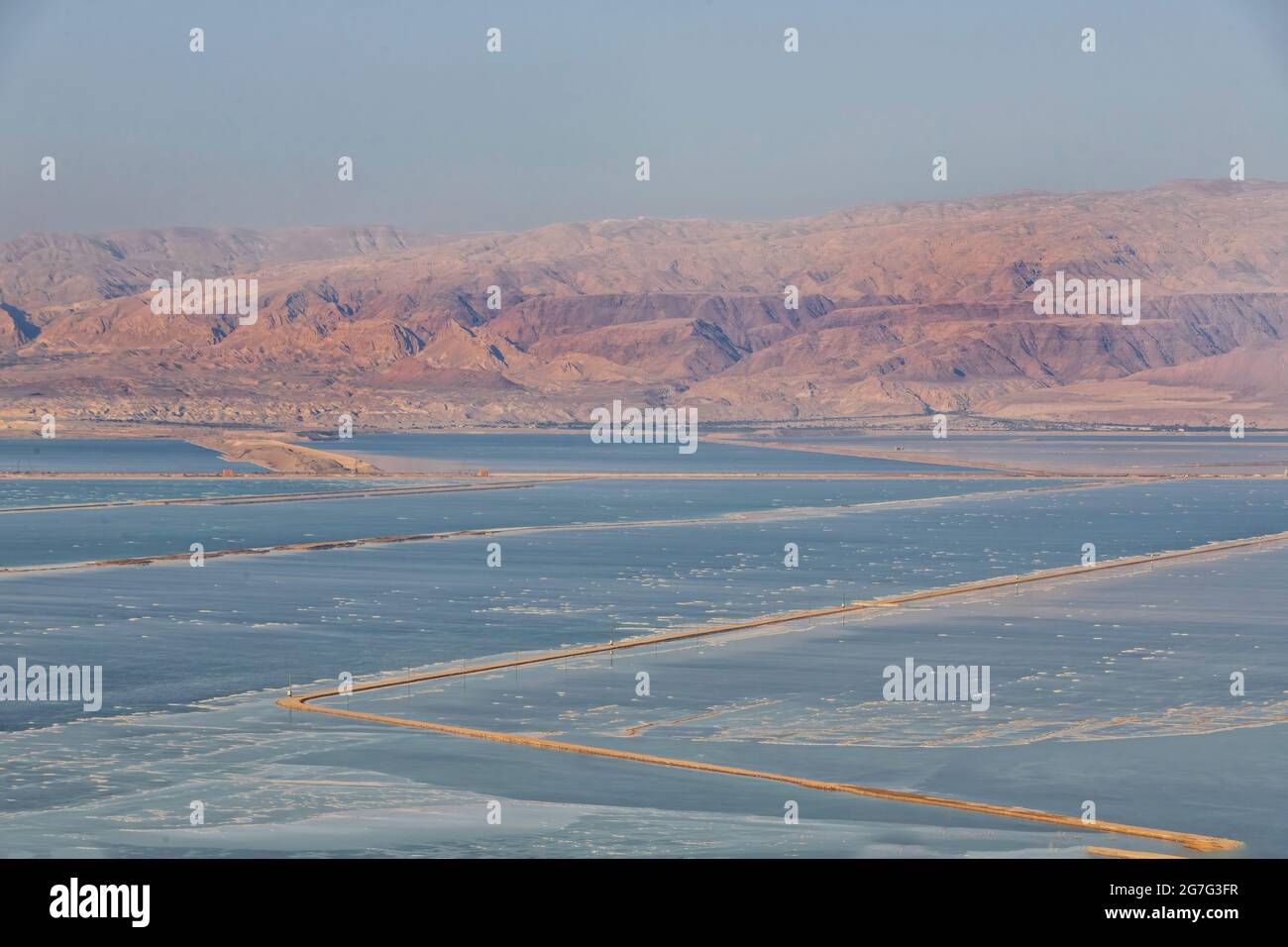 View of the Jordanian mountains through the saline waters of the Dead Sea at sunset. Israel Stock Photo