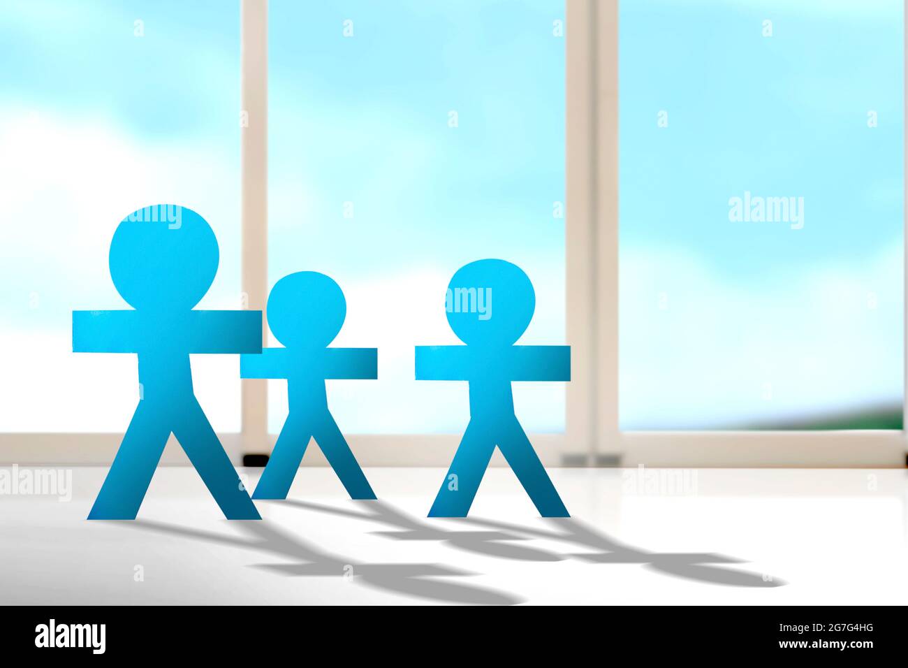 Blue people paper standing with the window background. World Population Day concept Stock Photo