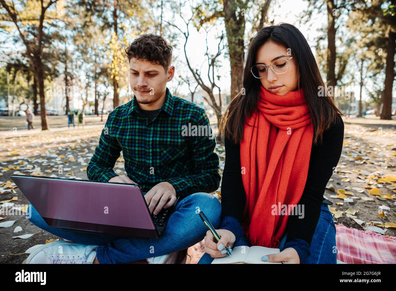 young couple using laptop to work outdoors Stock Photo