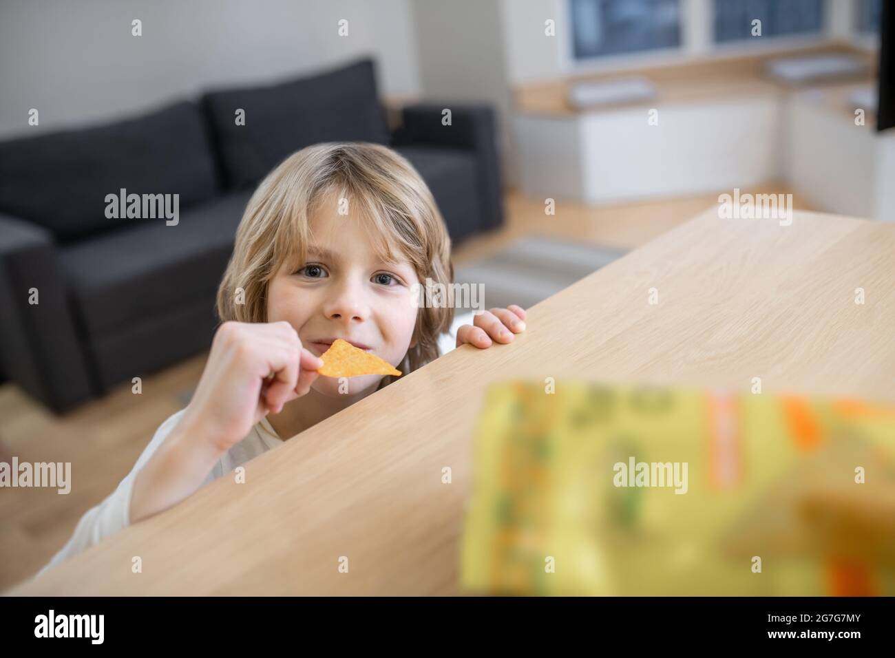 Close up picture of a cute boy eating potato chips Stock Photo