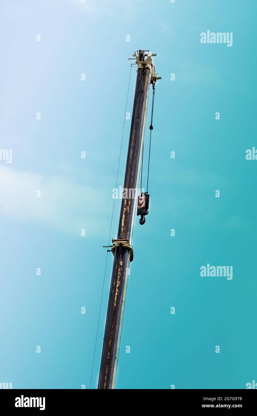 Raised boom of 100ton mobile crane against the sky. Extended