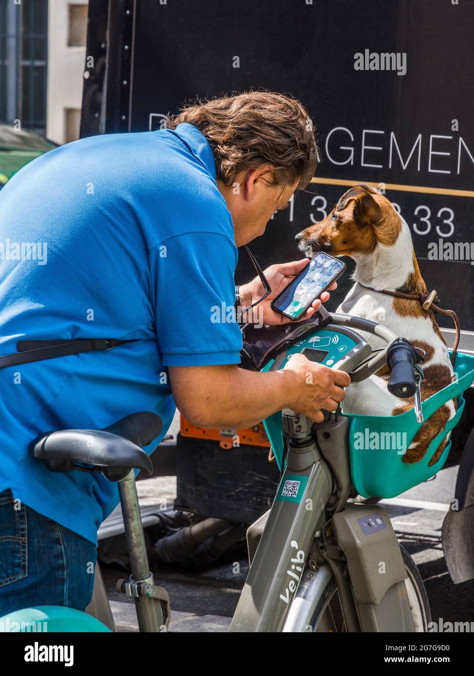 Man with dog planning route using cycle hire transportation - Paris, France. Stock Photo