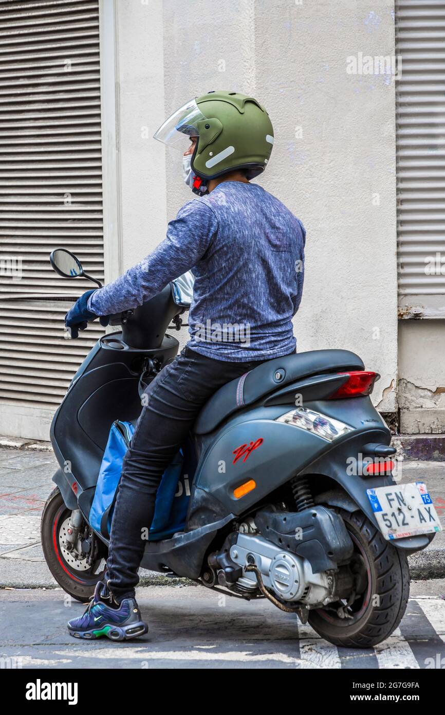 Man on scooter waiting in street - Paris, France. Stock Photo