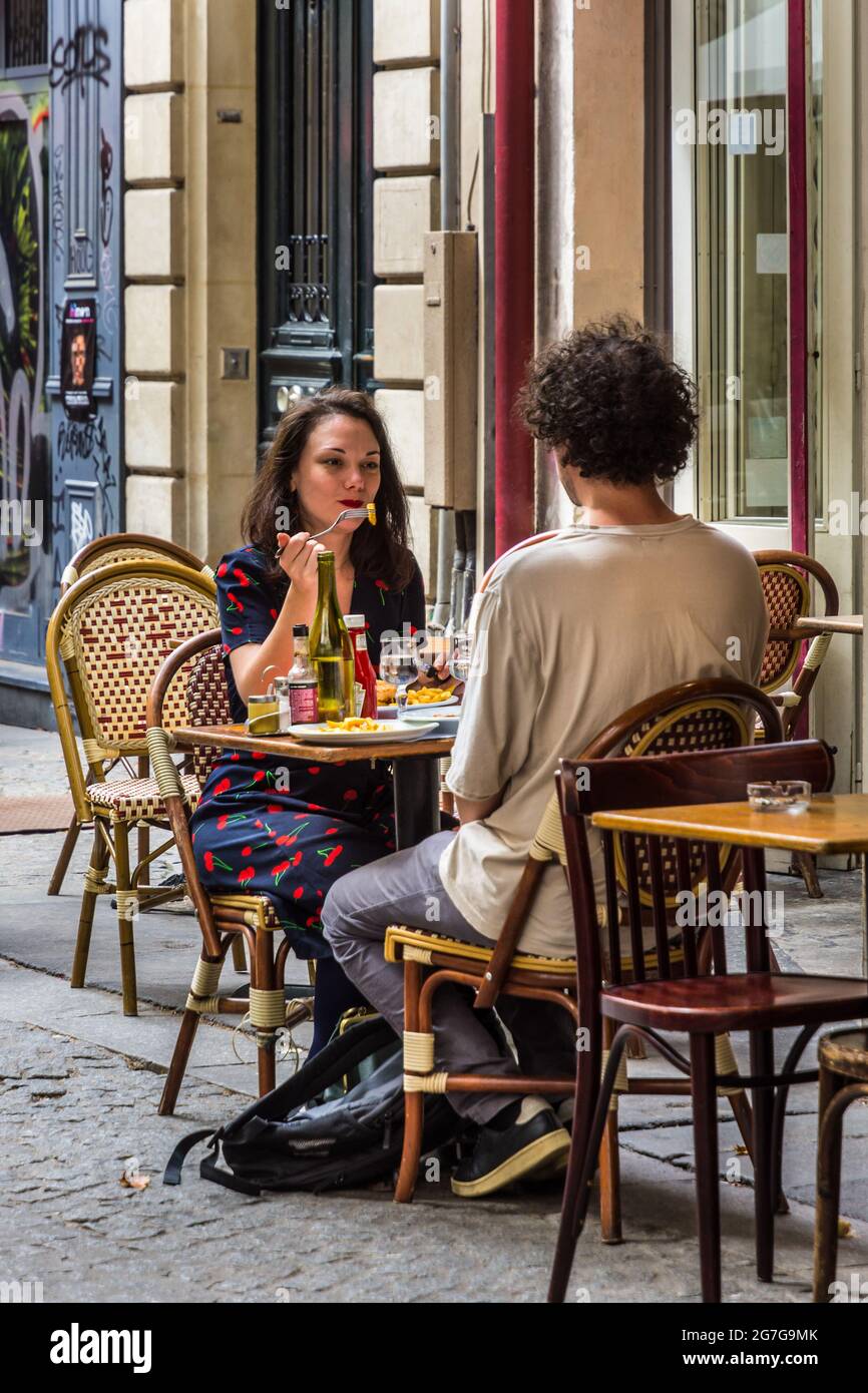 Young couple eating lunch outdoors on restaurant terrace - Paris, France. Stock Photo