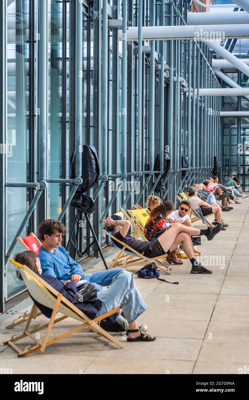 People relaxing in deckchairs on upper level of Centre Pompidou art gallery - Paris, France. Stock Photo